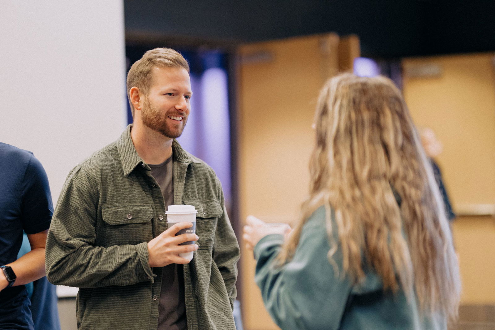 Man and woman talking holding coffee